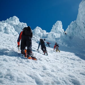 Climbers ascending snowy slope past ice seracs