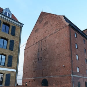 Historic red brick warehouse above autumn leaves
