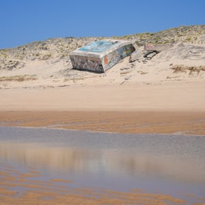 Graffiti covered concrete bunker on a sandy dune