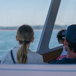 Woman with blonde ponytail gazing at sea from boat