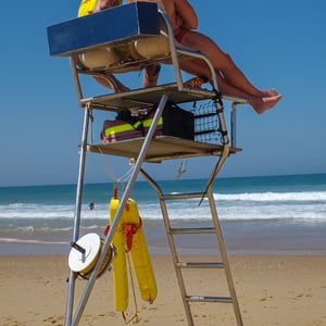 Two lifeguards watching the ocean from a beach tower