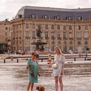 Women and dog wading in a Bordeaux reflecting pool
