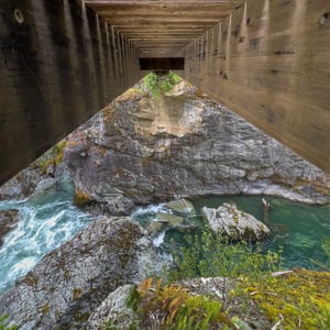 View beneath a wooden bridge over a turquoise river
