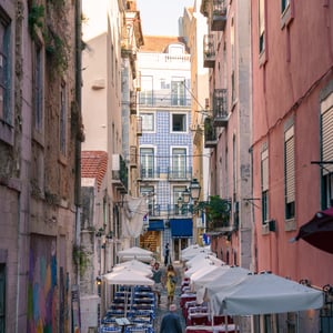 Narrow cobblestone street with outdoor cafe tables