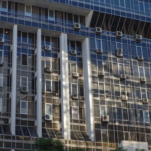 Glass office facade with air conditioners and concrete columns