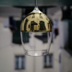 Upside down wine glass reflecting a sunlit street scene