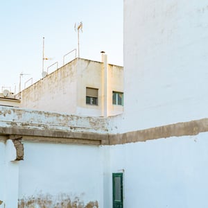 Weathered white wall with green door