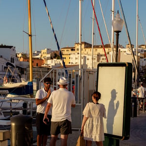Friends chatting on harbor promenade at sunset