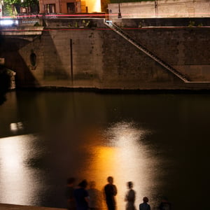 Night gathering by the river with blurred figures