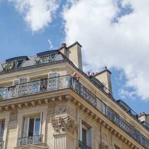 Haussmann building with ornate balconies under blue sky