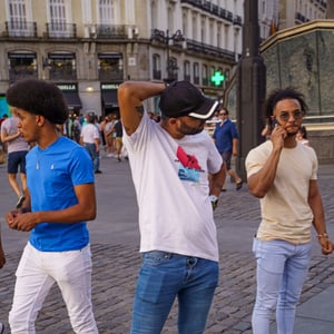 Three men on a cobblestone city street